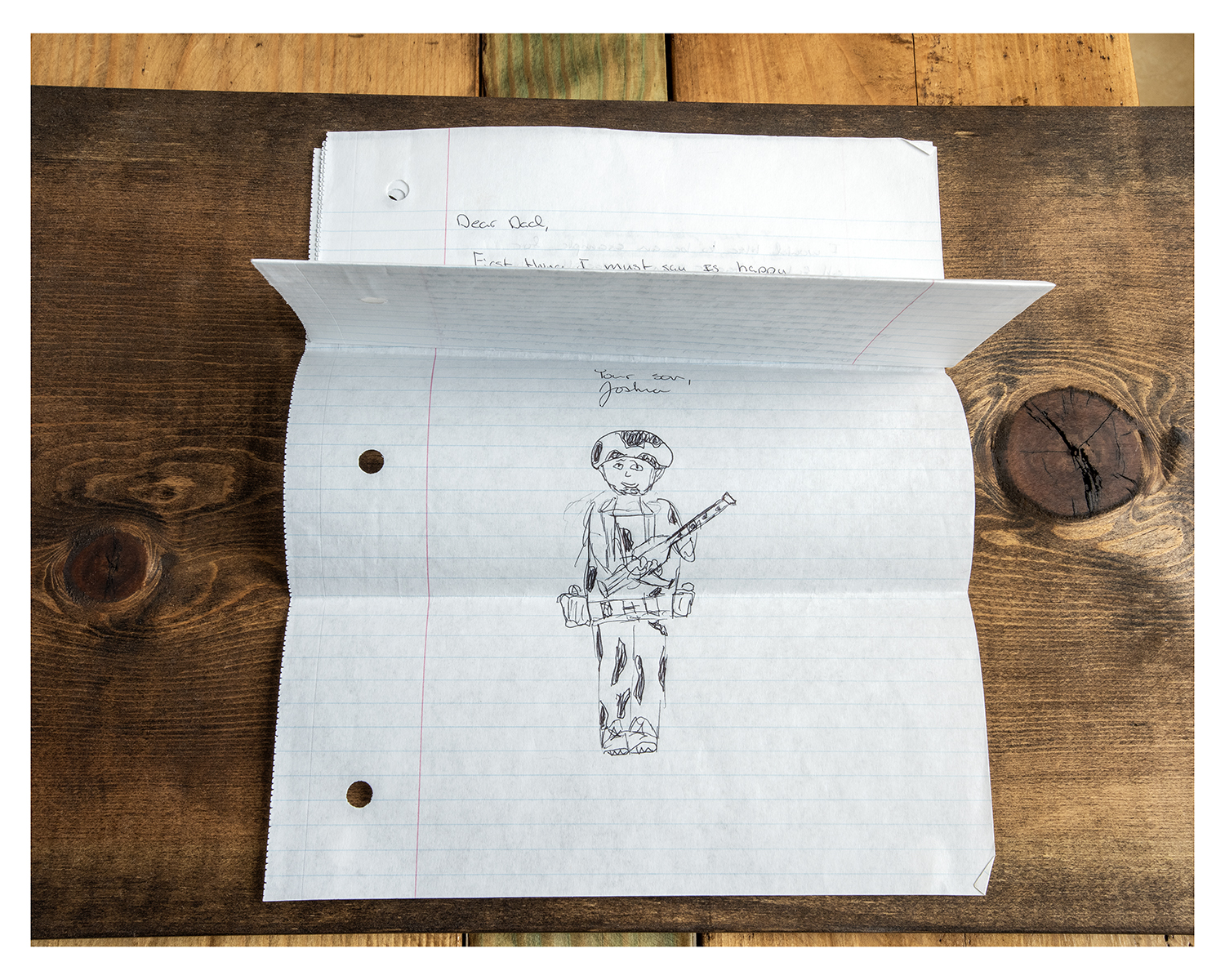 folded paper with drawing of person with gun 