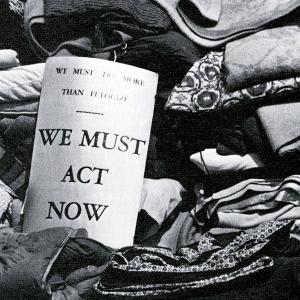 Sign reads 'We Must Act Now'